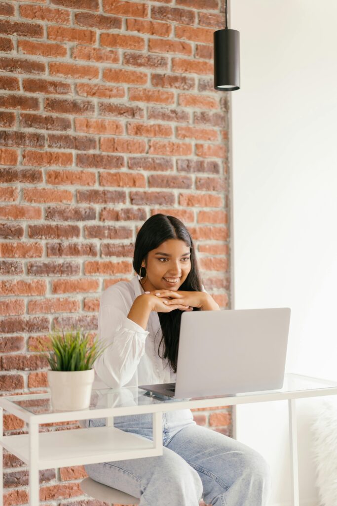 A young woman studies online using a laptop at home, symbolizing modern e-learning and technology.